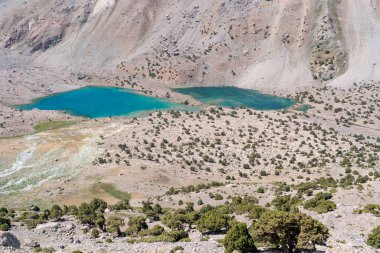 Temiz mavi gökyüzü, kayalık tepeler ve Tacikistan 'daki Fann dağlarında taze dağ gölü olan güzel dağ yürüyüşü yolu.
