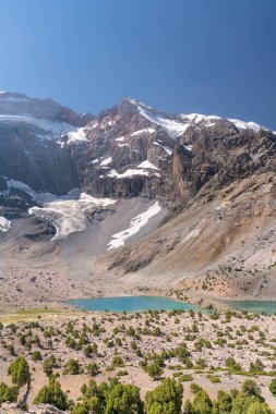 Temiz mavi gökyüzü, kayalık tepeler ve Tacikistan 'daki Fann dağlarında taze dağ gölü olan güzel dağ yürüyüşü yolu.