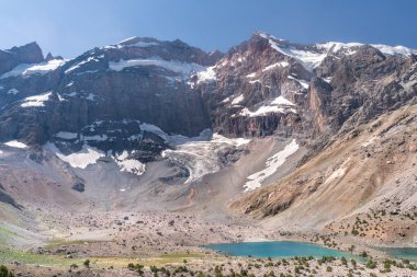 Temiz mavi gökyüzü, kayalık tepeler ve Tacikistan 'daki Fann dağlarında taze dağ gölü olan güzel dağ yürüyüşü yolu.