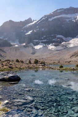 Temiz mavi gökyüzü, kayalık tepeler ve Tacikistan 'daki Fann dağlarında taze dağ gölü olan güzel dağ yürüyüşü yolu.