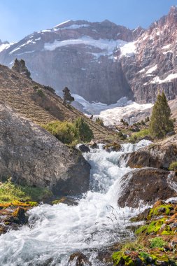 Temiz mavi gökyüzü, kayalık tepeler ve Tacikistan 'daki Fann dağlarındaki taze dağ deresi ile güzel dağ yürüyüşü yolu.