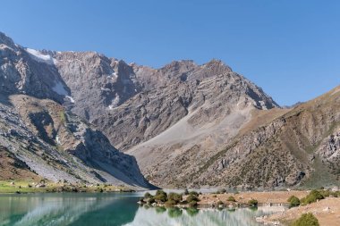 Pamir sıradağları manzarası ve Tacikistan 'daki Fann Dağları' ndaki Kulikalon Gölü 'ndeki huzurlu kamp alanı. Saf buz gölünün rengarenk yansıması.