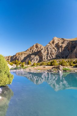 Pamir sıradağları manzarası ve Tacikistan 'daki Fann Dağları' ndaki Kulikalon Gölü 'ndeki huzurlu kamp alanı. Saf buz gölünün rengarenk yansıması.
