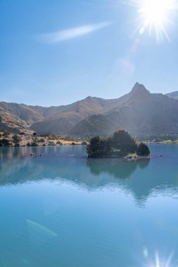 Pamir sıradağları manzarası ve Tacikistan 'daki Fann Dağları' ndaki Kulikalon Gölü 'ndeki huzurlu kamp alanı. Saf buz gölünün rengarenk yansıması.