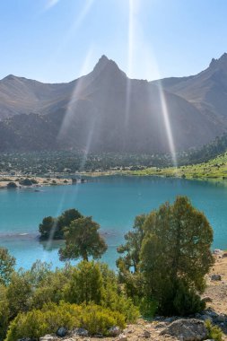 Pamir sıradağları manzarası ve Tacikistan 'daki Fann Dağları' ndaki Kulikalon Gölü 'ndeki huzurlu kamp alanı. Saf buz gölünün rengarenk yansıması.