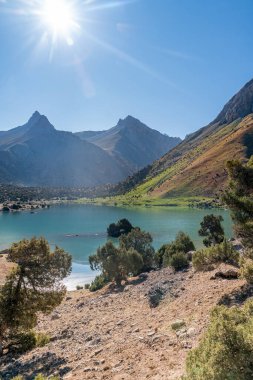 Pamir sıradağları manzarası ve Tacikistan 'daki Fann Dağları' ndaki Kulikalon Gölü 'ndeki huzurlu kamp alanı. Saf buz gölünün rengarenk yansıması.