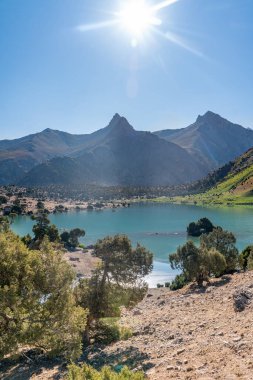 Pamir sıradağları manzarası ve Tacikistan 'daki Fann Dağları' ndaki Kulikalon Gölü 'ndeki huzurlu kamp alanı. Saf buz gölünün rengarenk yansıması.