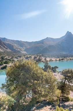 Pamir sıradağları manzarası ve Tacikistan 'daki Fann Dağları' ndaki Kulikalon Gölü 'ndeki huzurlu kamp alanı. Saf buz gölünün rengarenk yansıması.