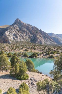 Pamir sıradağları manzarası ve Tacikistan 'daki Fann Dağları' ndaki Kulikalon Gölü 'ndeki huzurlu kamp alanı. Saf buz gölünün rengarenk yansıması.
