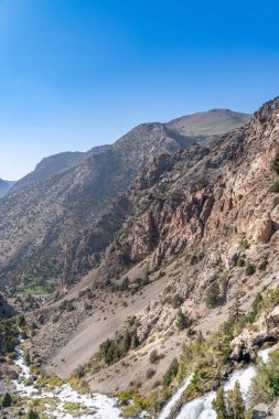 Güzel dağ yürüyüşü yolu açık mavi gökyüzü ve Tacikistan 'daki Fann dağlarında kayalık tepeler.