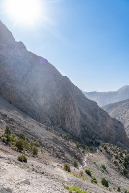 Güzel dağ yürüyüşü yolu açık mavi gökyüzü ve Tacikistan 'daki Fann dağlarında kayalık tepeler.