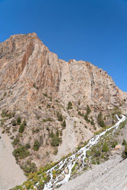 Güzel dağ yürüyüşü yolu açık mavi gökyüzü ve Tacikistan 'daki Fann dağlarında kayalık tepeler.