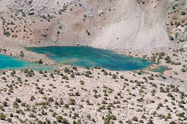 Temiz mavi gökyüzü, kayalık tepeler ve Tacikistan 'daki Fann dağlarında taze dağ gölü olan güzel dağ yürüyüşü yolu.