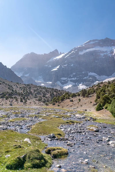 青い空と岩場の丘とタジキスタンのファン山脈の新鮮な渓流を持つ美しい山のトレッキング道路 — ストック写真