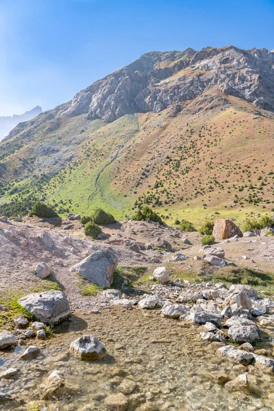 Pamir sıradağları manzarası ve Tacikistan 'daki Fann Dağları' ndaki Kulikalon Gölü 'ndeki huzurlu kamp alanı. Saf buz gölünün rengarenk yansıması.