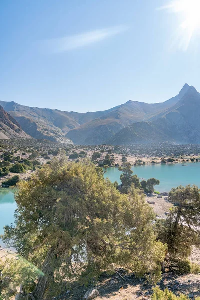 Pamir sıradağları manzarası ve Tacikistan 'daki Fann Dağları' ndaki Kulikalon Gölü 'ndeki huzurlu kamp alanı. Saf buz gölünün rengarenk yansıması.