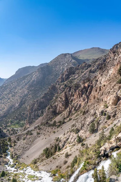 Güzel dağ yürüyüşü yolu açık mavi gökyüzü ve Tacikistan 'daki Fann dağlarında kayalık tepeler.