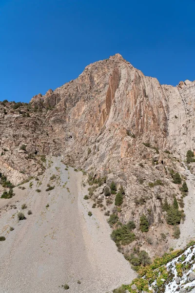 Güzel dağ yürüyüşü yolu açık mavi gökyüzü ve Tacikistan 'daki Fann dağlarında kayalık tepeler.