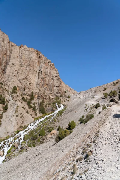 Güzel dağ yürüyüşü yolu açık mavi gökyüzü ve Tacikistan 'daki Fann dağlarında kayalık tepeler.