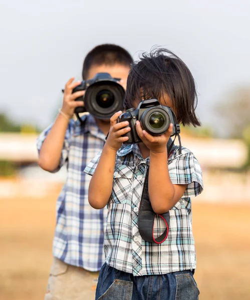 Criança atirando com uma câmera SLR moderna — Fotografia de Stock