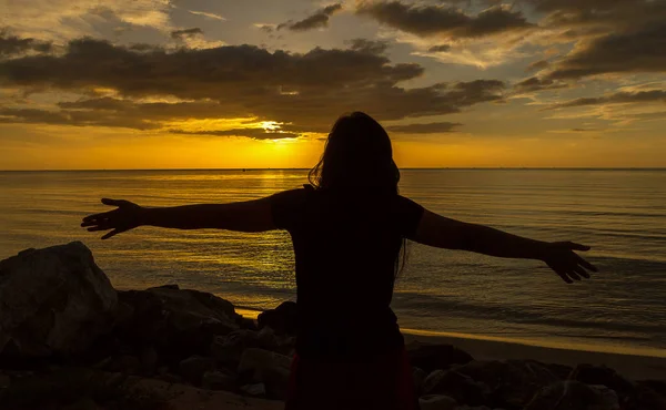 Silhouette di donna che prega sul bellissimo sfondo del tramonto — Foto Stock