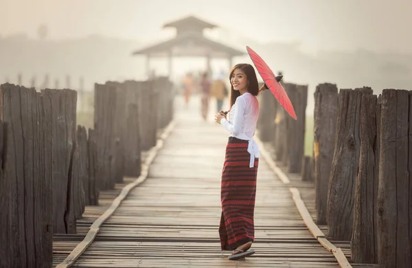 Femme birmane tenant parapluie rouge traditionnel et marche — Photo