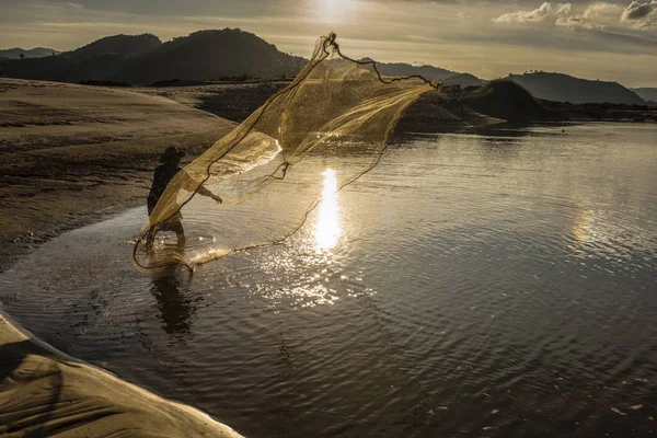 Pescatore in azione durante la pesca nel lago — Foto Stock