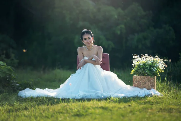 Портрет красивой невесты, сидящей на стуле на улице — стоковое фото