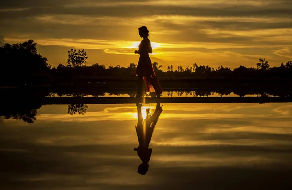 Silhouet van de vrouw lopen op het strand — Stockfoto