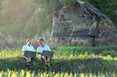 Bir dizüstü bilgisayar açık havada kullanarak mutlu çocuk
