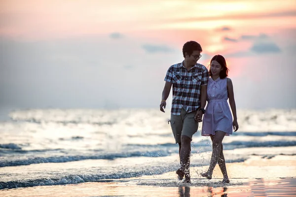 カップルがビーチを歩いている。若い幸せな異人種間のカップルがビーチを歩く — ストック写真