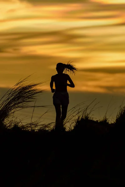 Žena běží sama při krásném západu slunce — Stock fotografie