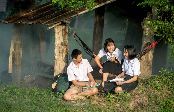 Estudantes asiáticos em uniforme estudando juntos ao ar livre . — Fotografia de Stock