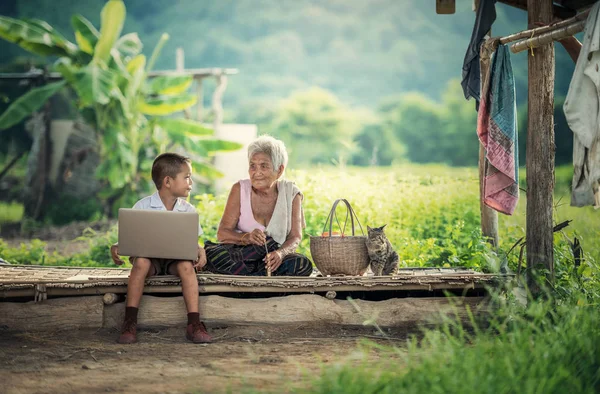 Menino feliz e avó usando laptop — Fotografia de Stock