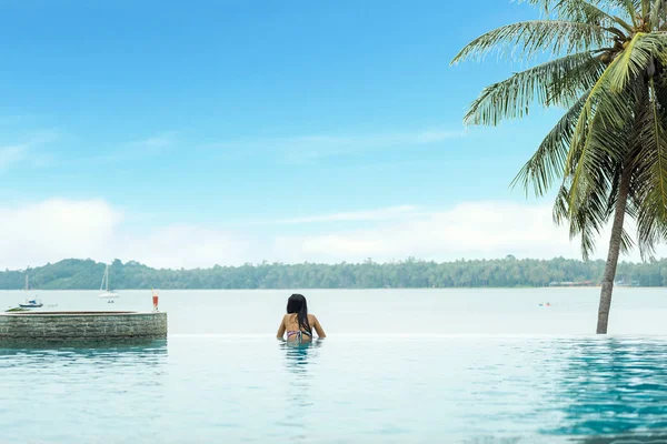 Sonsuz yüzme havuzunda dinlenen bir kadın — Stok fotoğraf