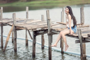 Düşünme kadın iskelede oturuyordu