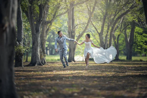 Bruden och brudgummen kör och park och håller händerna — Stockfoto