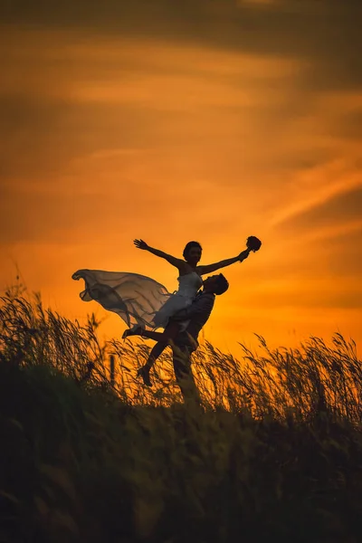 Apenas casado amoroso casal hipster em vestido de noiva e terno no campo — Fotografia de Stock