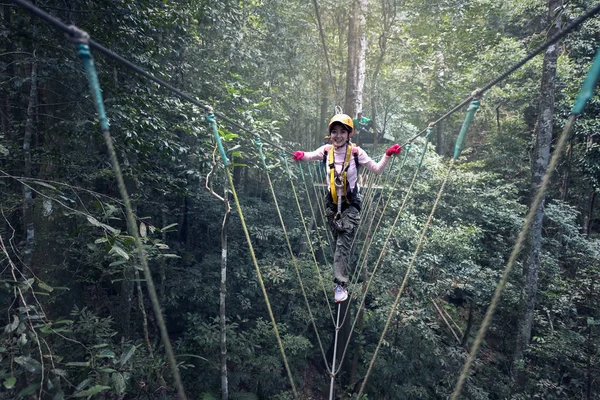 Vrouw op kabels in een avonturenpark op een moeilijk parcours — Stockfoto