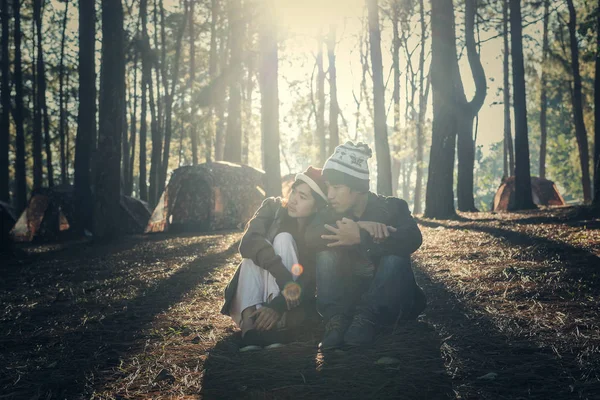 Portrait of hipster couple sitting together under a tree in forest — Stock Photo, Image