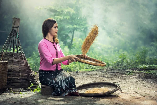 Vacker flicka vanning ris separat mellan ris och risskal — Stockfoto