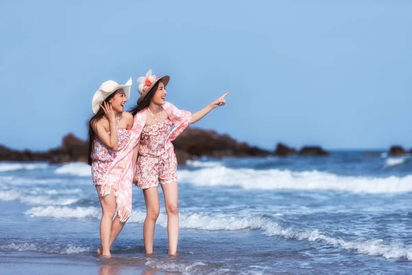 Vackra vänner njuter av en promenad på stranden en solig dag — Stockfoto