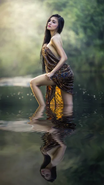夏天穿沙龙衣服在小溪中摆出性感的苗条身材的模特 — 图库照片