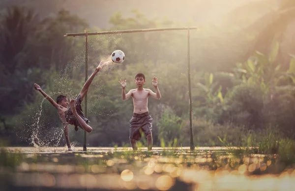 アジアの子供たちはタイの田舎の川でサッカーをする — ストック写真