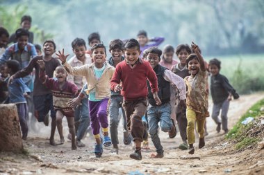 MATHURA, Hindistan - 23 Şubat 2018: Agra, Uttar Pradesh, Hindistan 'da fotoğraf çekmek için koşan gürültücü Hintli çocuklar grubu.