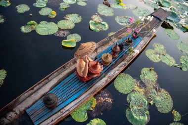 Myanmar 'daki Inle Gölü' ndeki In Dain Khone köyünde sabah sandaldaki Burmalı Intha 'lı kadın..