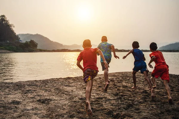 Πίσω Όψη Ξένοιαστων Αγοριών Που Τρέχουν Στο Νερό Και Διασκεδάζουν — Φωτογραφία Αρχείου