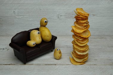 Tahta ekranda kızartılmış cips yığınıyla Yeni Sebze Ailesini Koltukta Gösteren Patates..