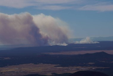 Kuzey Arizona 'daki önemli bir yangından çıkan duman Flagstaff çevresindeki dağlardan çok görünür..