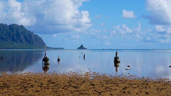 A beautiful summer day on Kaneohe Bay, Hawaii shows still reflective water at low tide.
